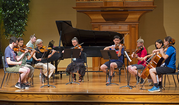 string players and pianist playing quintet